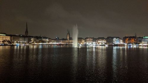 Illuminated buildings at waterfront at night