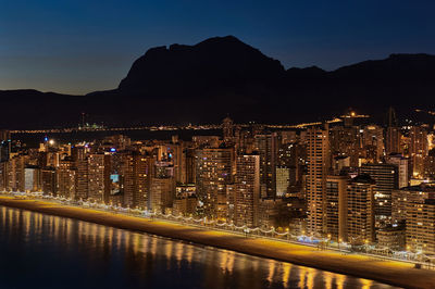 Illuminated cityscape against sky at night