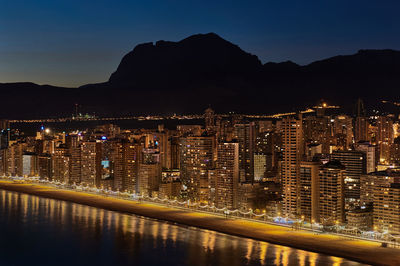 Illuminated cityscape against sky at night