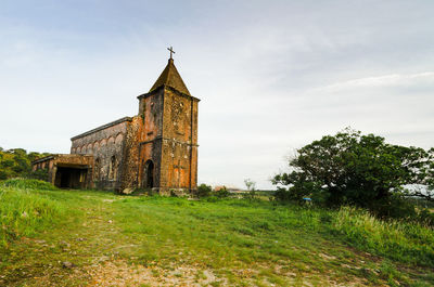 Old building on field against sky