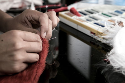 Cropped hand sewing textile in workshop