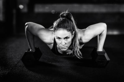 Cross training. young woman exercising with dumbbells