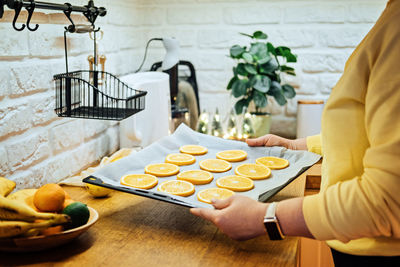 How to dry orange slices for holiday decor. process of drying orange slices in the oven. woman