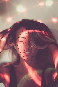 Close-up of young woman with star shape glitters