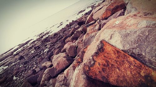 Rock formations by sea against clear sky
