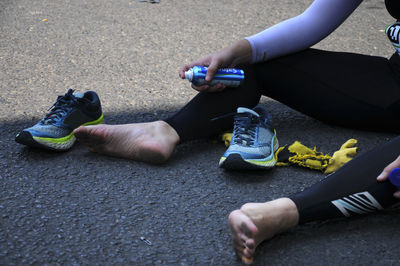 Low section of woman sitting on road