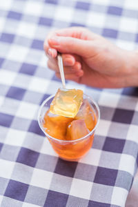 Midsection of woman holding drink on table
