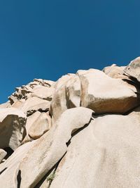 Low angle view of rock formation against clear blue sky