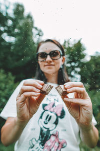 Portrait of woman holding sunglasses