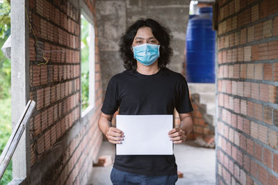 Portrait of man standing against wall