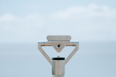 Close-up of coin-operated binoculars against sky