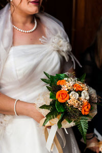 Midsection of woman holding flower bouquet