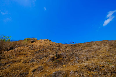 Low angle view of mountain against blue sky