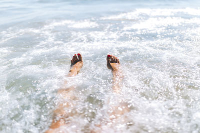 Young woman enjoying swimming in sea on sunny day