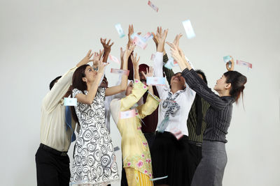 Cheerful business colleagues looking up against white background