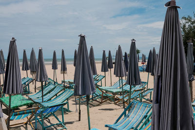 Panoramic shot of empty chairs on beach against sky