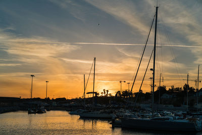 Sailboats in sea at sunset