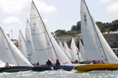 People sailing on sailboat against sky