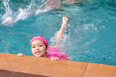 Portrait of happy girl swimming in pool