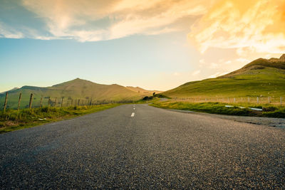 Empty road by mountain against sky