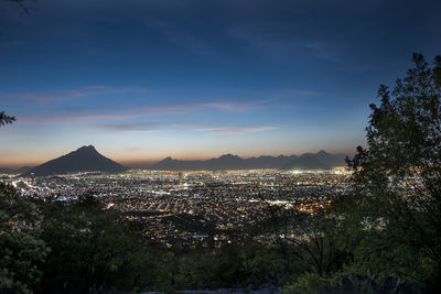 View of city lit up at sunset