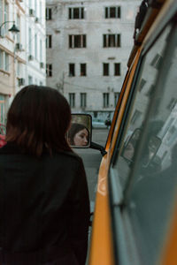 Rear view of woman walking on street in city