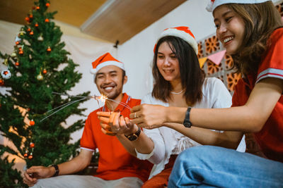 Friends using mobile phone while sitting on sofa at home