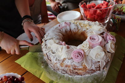 Midsection of woman holding rose bouquet on table