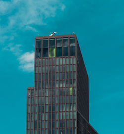 Low angle view of modern building against blue sky