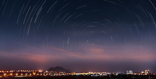 Illuminated city against sky at night