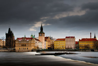 Buildings in city against cloudy sky