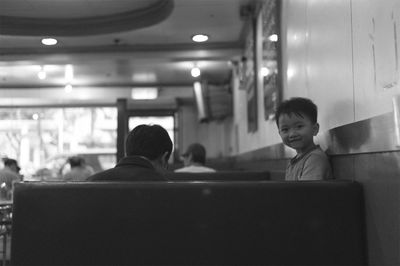 Rear view of boy sitting in corridor