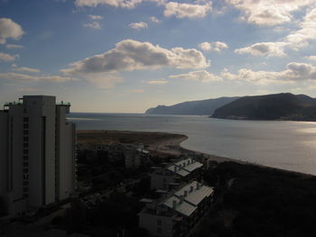 High angle view of buildings by sea against sky
