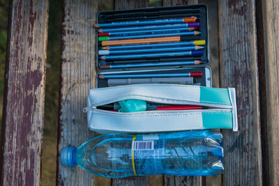 Directly above shot of school supplies and water bottle on table