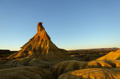 Rock formations on landscape against clear sky, bardenas reales, spain