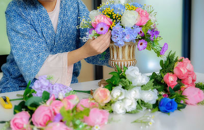 Midsection of woman holding flower bouquet