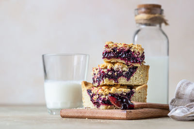 Homemade berries jam shortcrust squares and glass of milk.