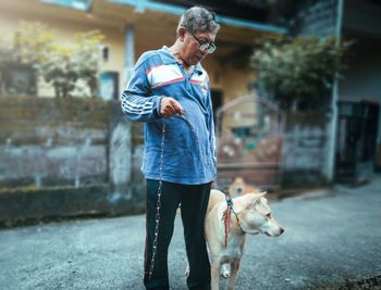 Full length of man with dog standing outdoors