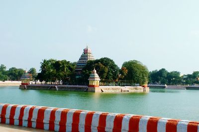 Temple by lake against clear sky