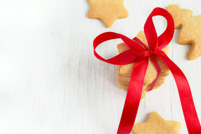 Stack of christmas homemade cookies stars with a red bow. space