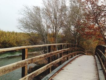 Footbridge over river against sky
