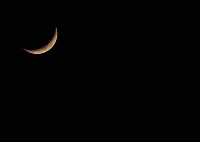 Low angle view of half moon against sky at night