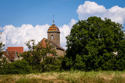 Trees and historic building against sky