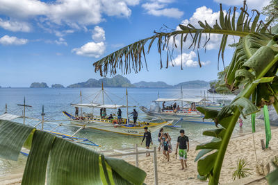 Panoramic view of people on beach against sky