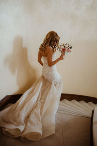 Rear view of bride holding bouquet on steps