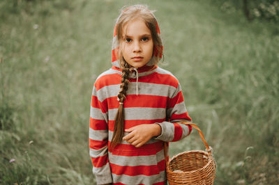 Upset or focused eight year old kid girl mushroom picker is seek for and picking mushrooms