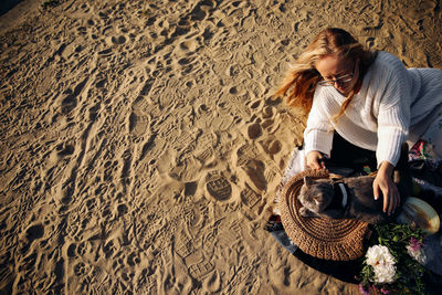 High angle view of woman sitting on sand