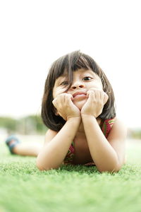 Portrait of girl lying on land at park