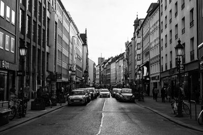 Cars on road in city against sky