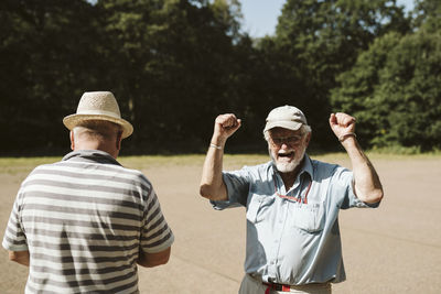 Rear view of men standing against trees